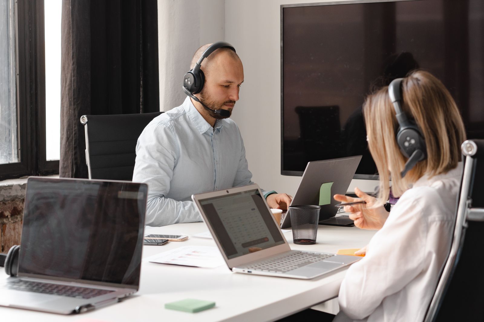 Two colleagues working at laptops in an office